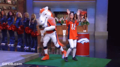 Woman In Broncos Jersey Next To Mascot On Stage GIF