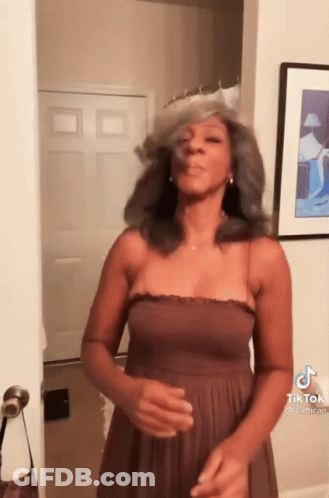 Woman In Brown Dress Making Funny Face At Door GIF