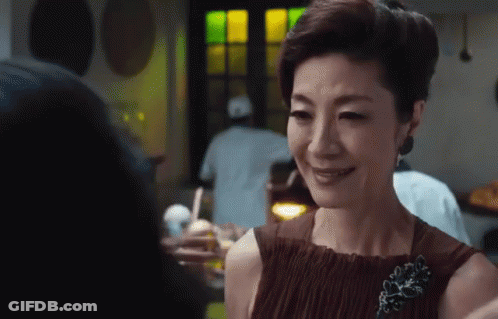Woman In Brown Dress Smiling With Brooch GIF