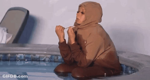 Woman In Brown Hoodie Kneeling In Pool GIF