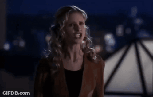 Woman In Brown Jacket In Front Of Dark Background GIF
