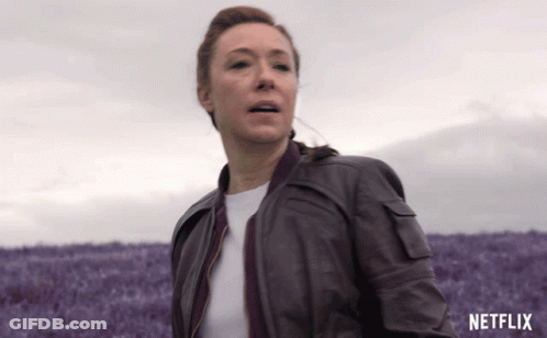 Woman In Brown Leather Jacket Running Through Purple Flowers GIF