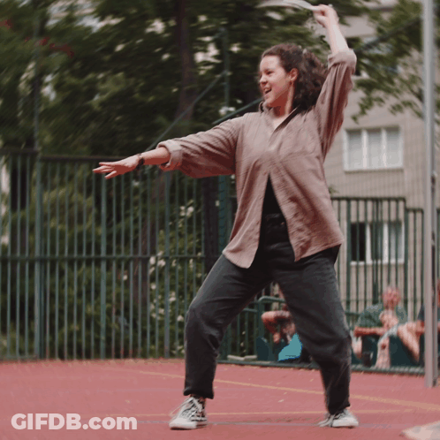 Woman In Brown Shirt And Black Jeans Dancing GIF