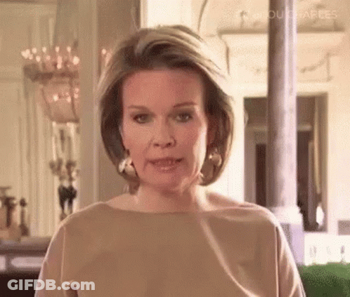 Woman In Brown Shirt And Earrings Talking GIF