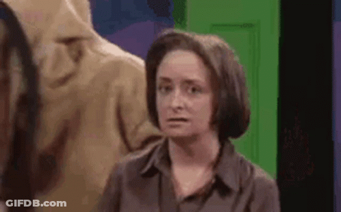 Woman In Brown Shirt In Front Of Green Door GIF