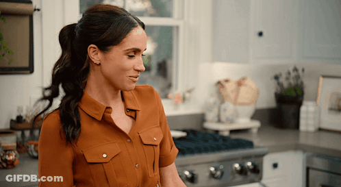 Woman In Brown Shirt In Kitchen GIF