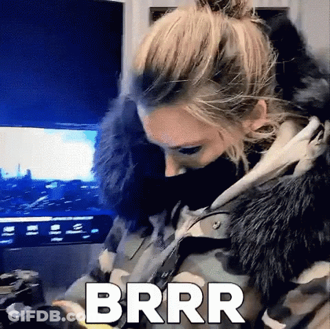 Woman In Camouflage Jacket And Fur Hood Sitting In Front Of TV GIF