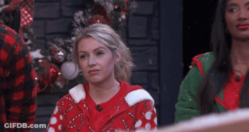Woman In Candy Cane Sweater And Man Looking At Each Other GIF