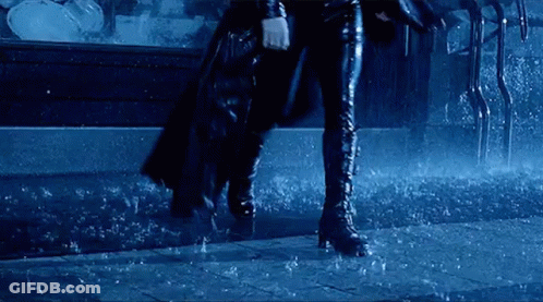 Woman In Cape And Boots Walking Through Rain GIF