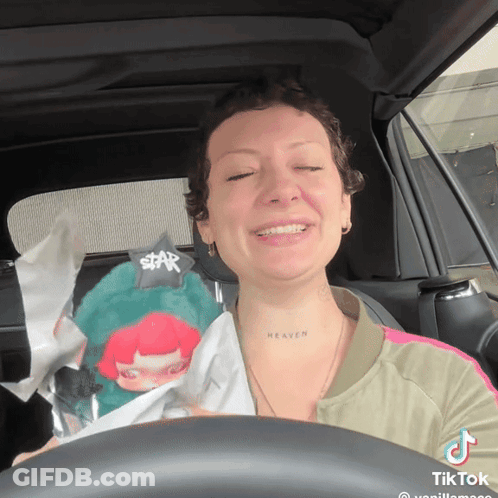 Woman In Car With Heaven Tattoo On Neck GIF