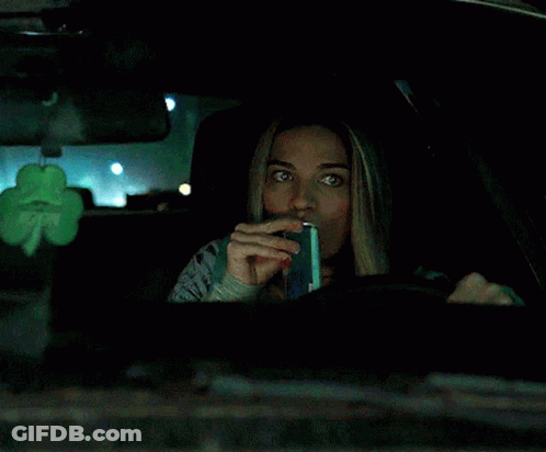 Woman In Car With Shamrock Hanging From Rear View Mirror GIF