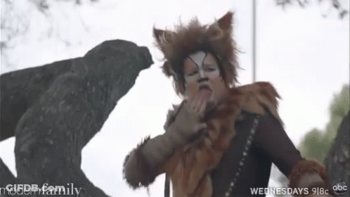 Woman In Cat Costume Standing In Front Of Statue GIF