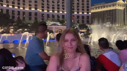 Woman In Chanel Earrings By Fountain At Night GIF