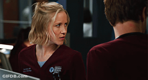 Woman In Chicago Medical Center Scrub Looking At Man GIF
