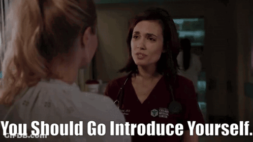 Woman In Chicago Medical Center Scrub Talking To Another Woman In Hospital Room GIF
