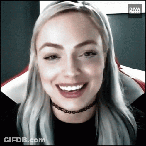Woman In Choker Smiling In Front Of Diva Banner GIF