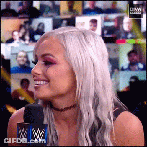 Woman In Choker Smiling In Front Of Diva Banner GIF