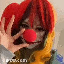 Woman In Clown Costume Holding Red Nose GIF