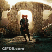 Woman In Clown Costume Standing In Front Of Brick Archway GIF