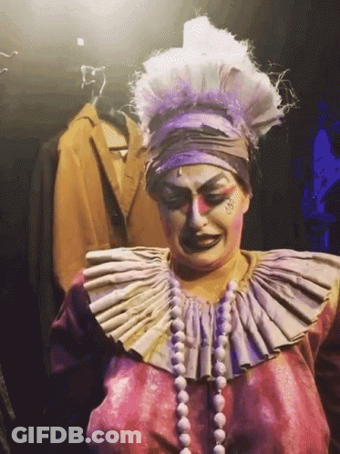 Woman In Clown Costume With Large Collar And Pearls GIF