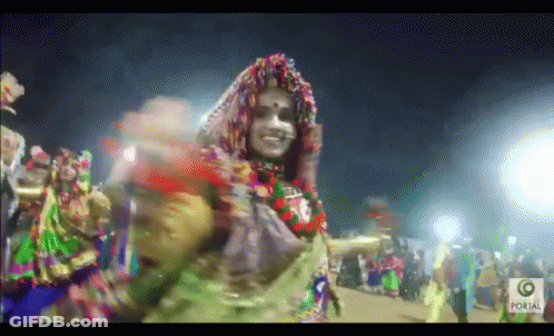 Woman In Colorful Costume Dancing Before Crowd With Portal GIF