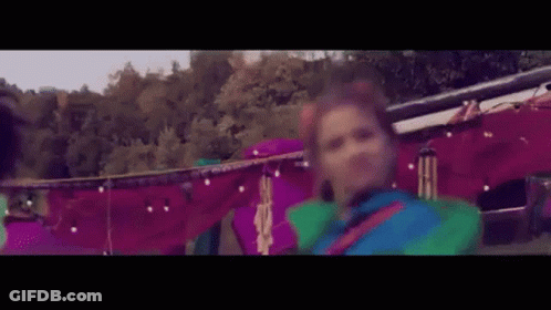 Woman In Colorful Costume Dancing In Front Of Tent GIF