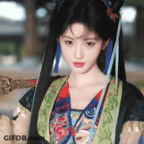 Woman In Colorful Costume Holding Sword GIF