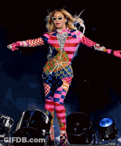 Woman In Colorful Outfit Holding Microphone On Stage GIF