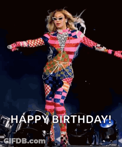 Woman In Colorful Outfit On Stage With Arms Outstretched GIF