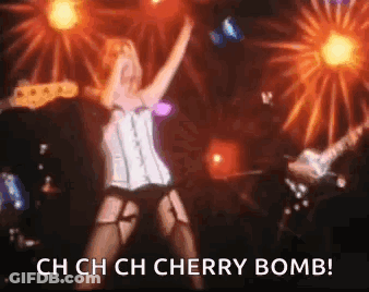 Woman In Corset Dancing On Stage With Guitar And Fireworks GIF