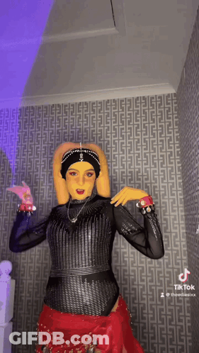 Woman In Costume Dancing In Front Of Patterned Wall GIF