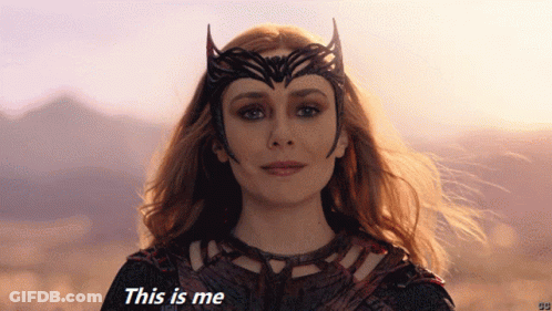 Woman In Costume Saying This Is Me In Front Of Mountains GIF