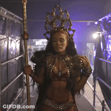 Woman In Costume With Crown Holding Pole GIF