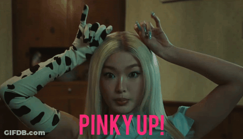 Woman In Cow Print Gloves Pinky Up GIF