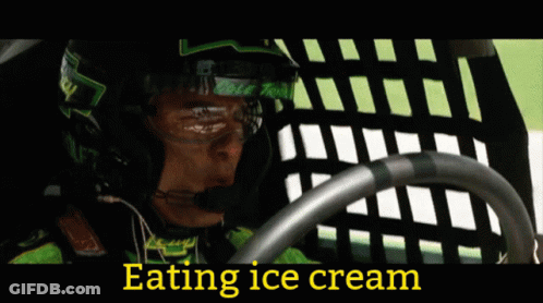 Woman In Cowboy Hat Eating Ice Cream In Front Of Racers GIF
