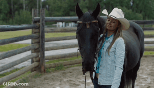 Woman In Cowboy Hat Next To Horse GIF