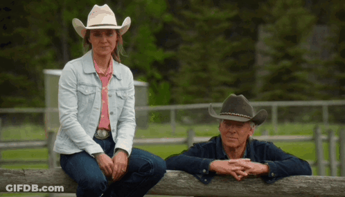 Woman In Cowboy Hat Next To Man Leaning On Wooden Fence GIF