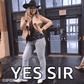 Woman In Cowboy Hat Thumbs Up Outside Building GIF