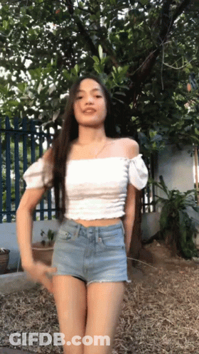Woman In Crop Top And Shorts Arms Outstretched On Beach GIF