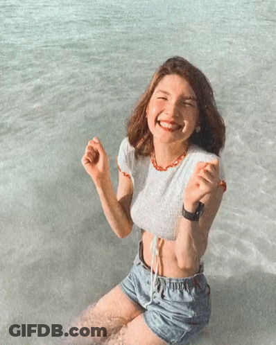 Woman In Crop Top And Shorts Kneeling In Water GIF