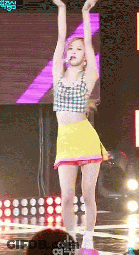 Woman In Crop Top And Yellow Skirt Dancing On Stage GIF