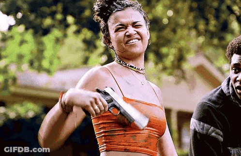 Woman In Crop Top Holding Gun Smiling GIF