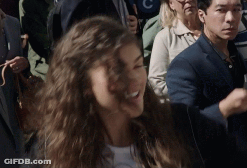 Woman In Crowd With Man In Suit And Woman With Letter C GIF