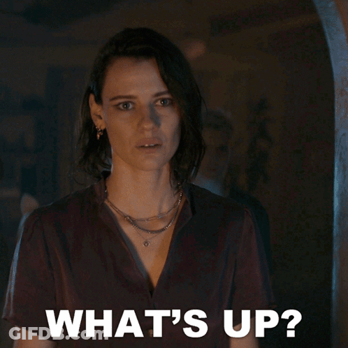 Woman In Dark Room Saying Whats Up GIF