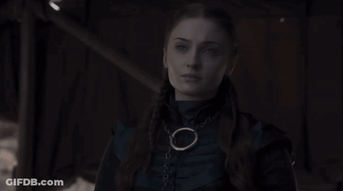 Woman In Dark Room Wearing Necklace With Circle GIF