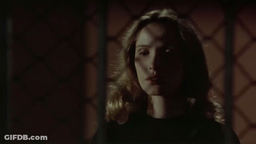 Woman In Dark Room With Hands On Neck GIF