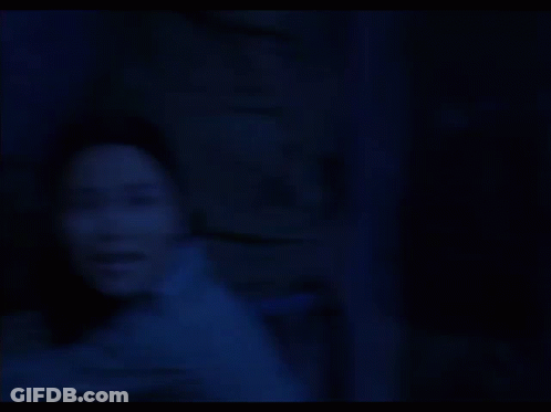 Woman In Dark Room With Ready Behind Her GIF