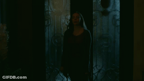 Woman In Dark Room With Wrought Iron Door GIF