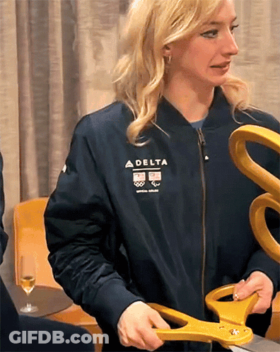 Woman In Delta Jacket Holding Scissors GIF
