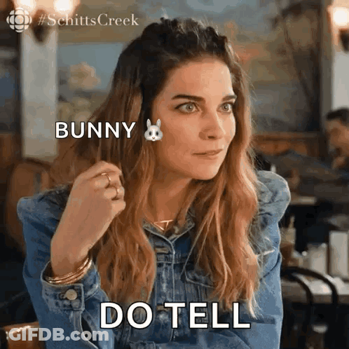 Woman In Denim Jacket Saying Do Tell GIF